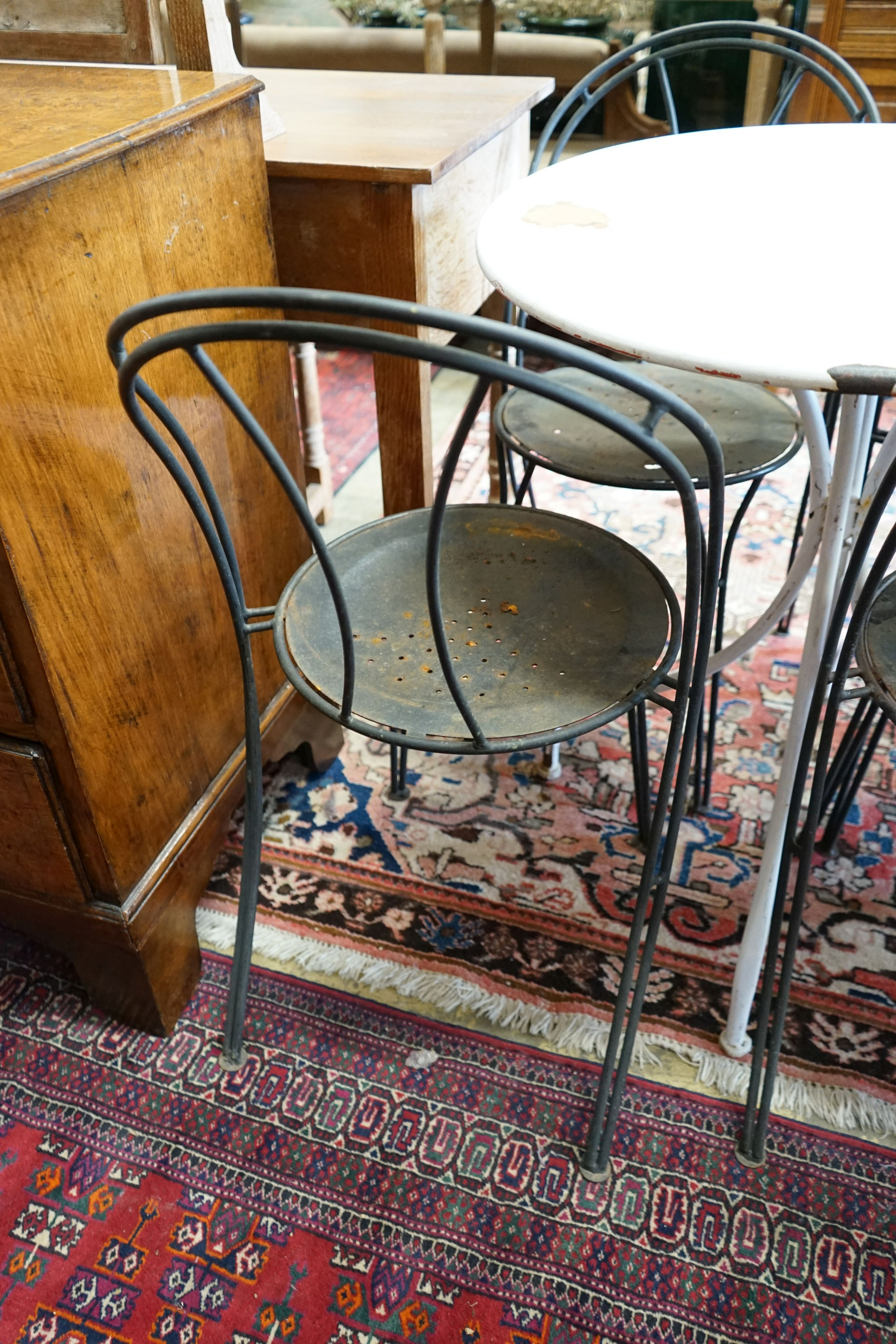 A circular metal garden table, diameter 70cm, height 76cm and four chairs